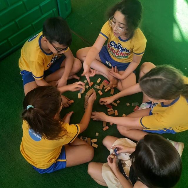 Crianças da Educação Infantil brincando no gramado